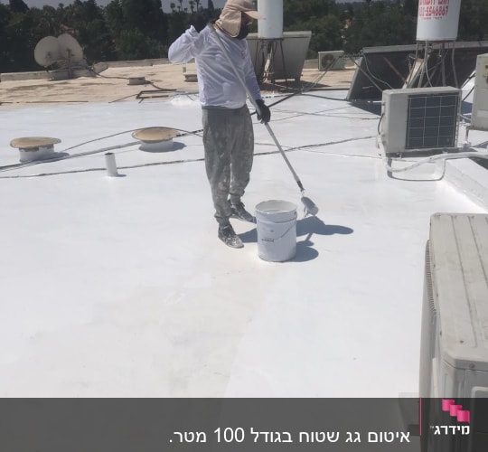 אדם מורח חומר איטום על גג עם רולר